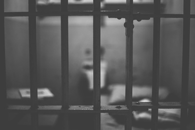 Black and white image of prison jail bars