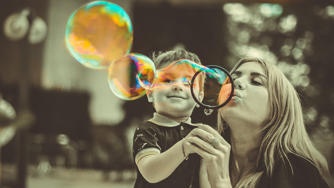 mom blowing bubbles with son