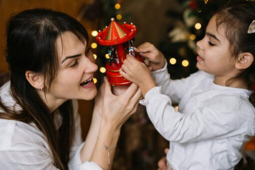 Mother and daughter preparing ornaments for a Christmas tree