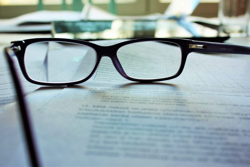 Pair of reading glasses resting on top of forms