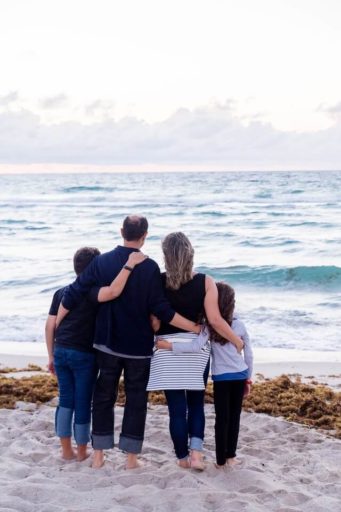 San Diego family embracing looking out to sea on the beach