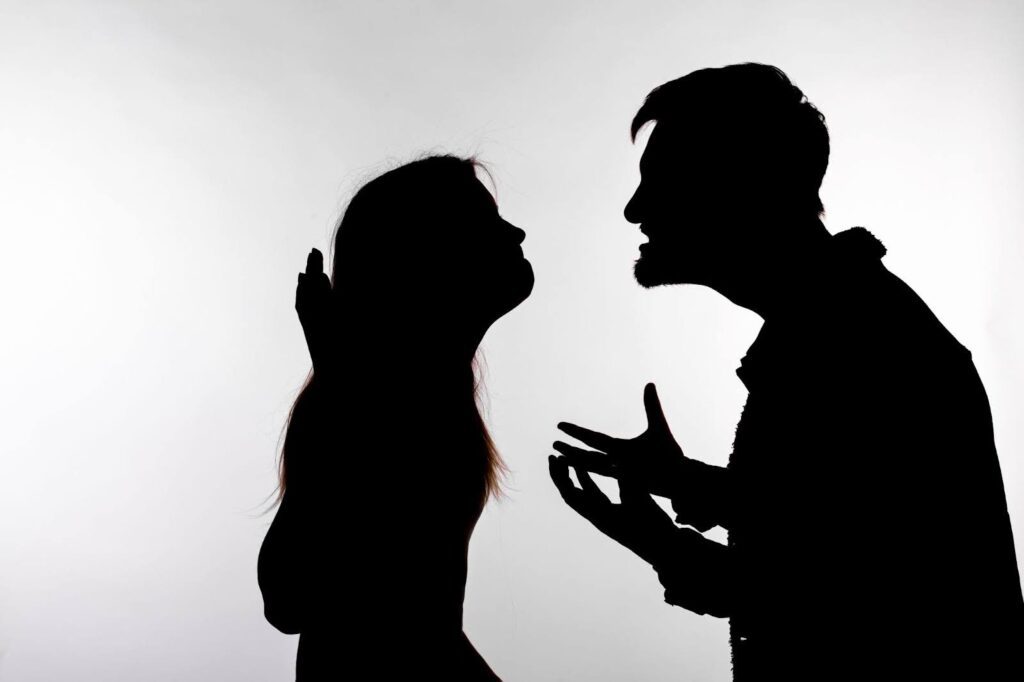 A silhouette of a couple angrily arguing