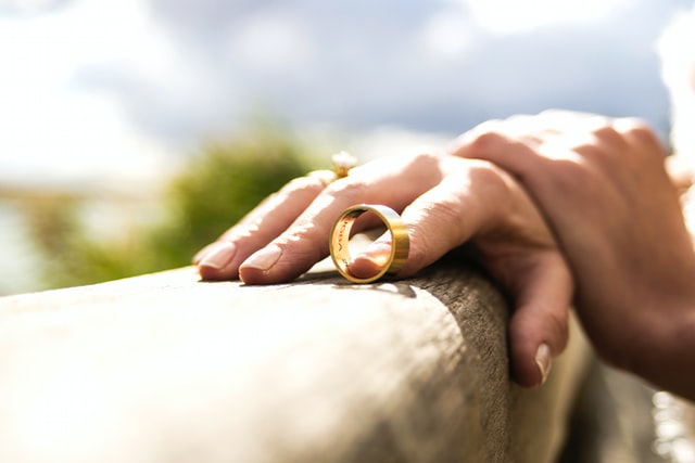 Hands on a railing holding a wedding band